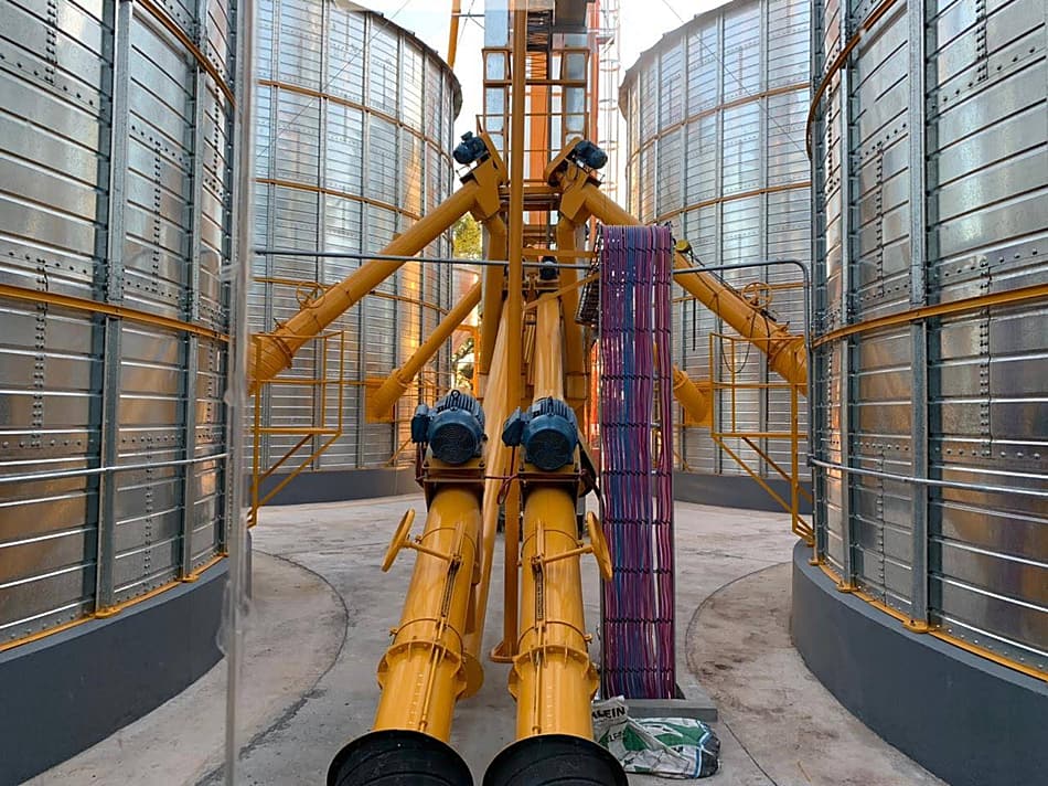 Sinfines extractores con motorreductor entre silos, al pie de la noria